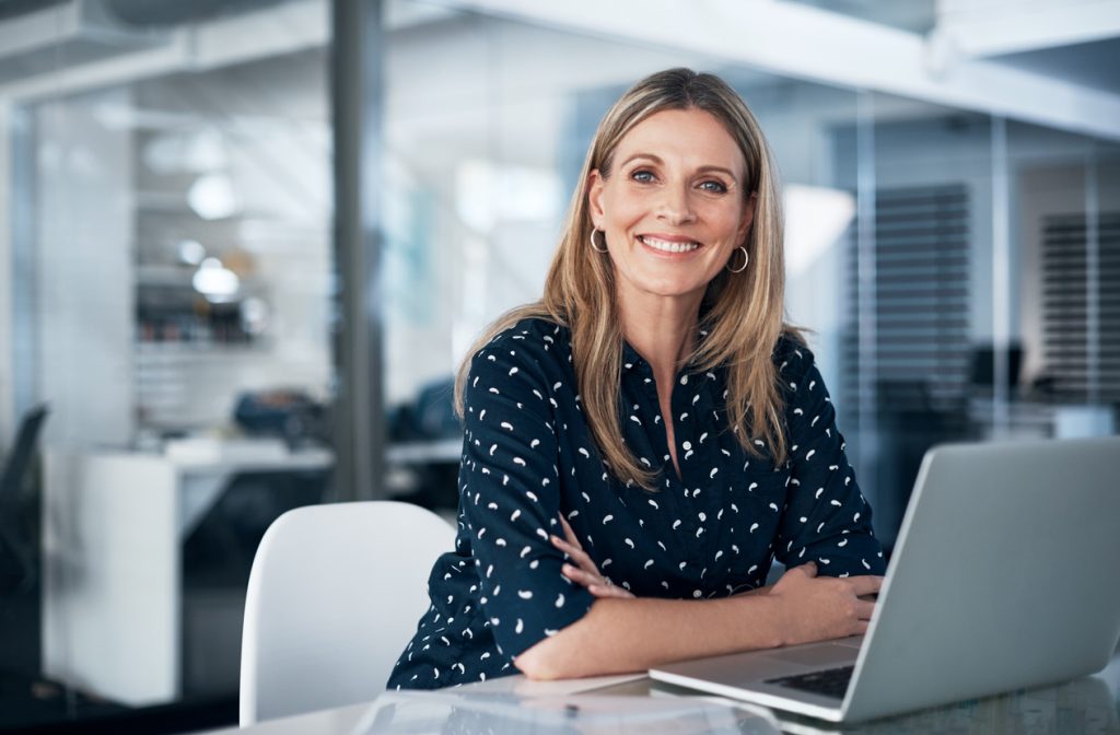 Business woman working at desk with laptop | RiskSphere